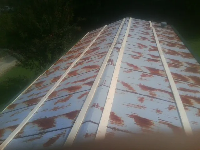 Rusted metal roof panels with new wood purlins before replacement — Storm Damage Roof Repair in West Camp by Roofing Brothers