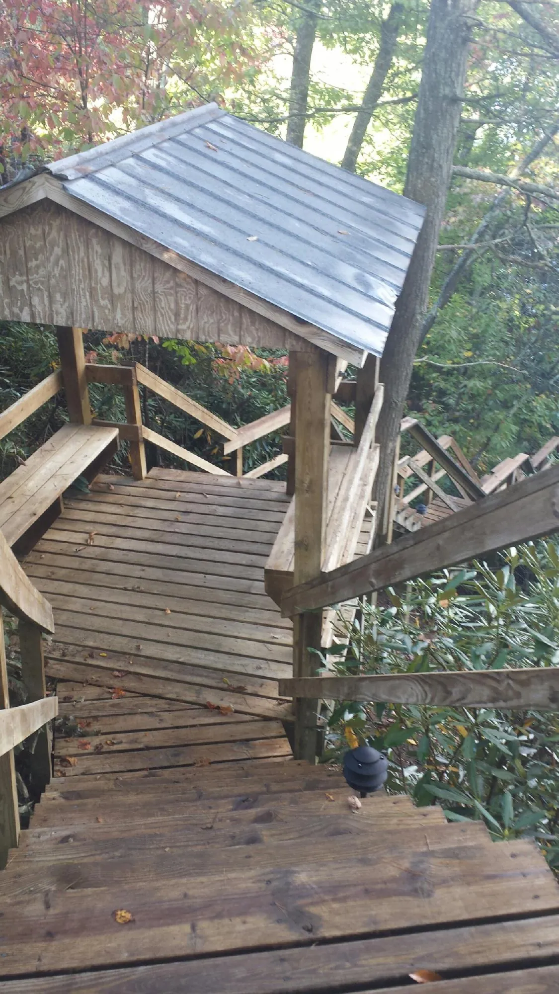 Metal roofed shelter over wooden steps on a wooded walkway — Skylight Repair & Installation work by our crew in West Camp