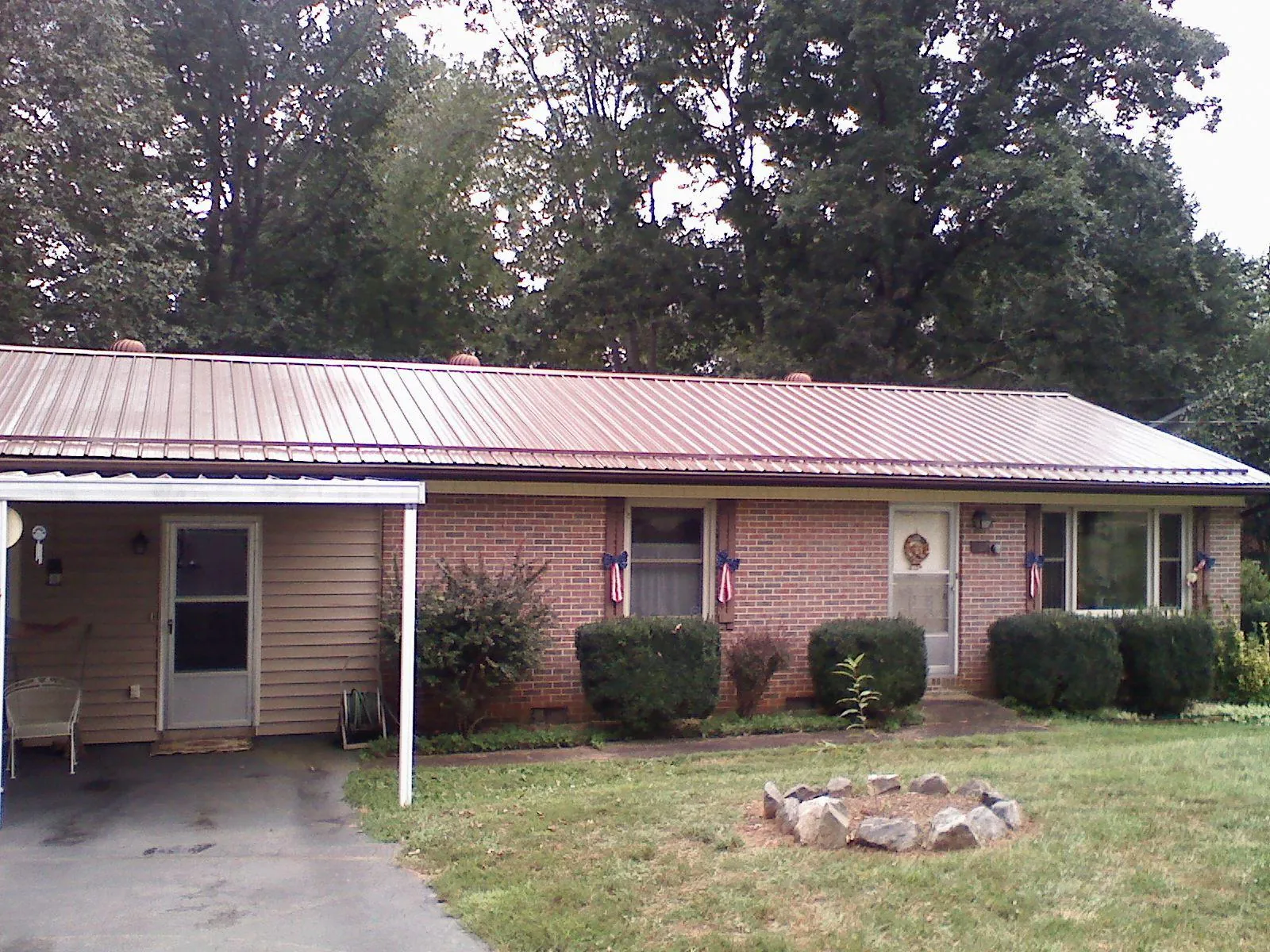 Bronze metal roof and carport on a brick ranch home — Roof Repair work by our crew in West Camp
